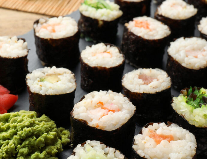 Tasty sushi rolls served on wooden table