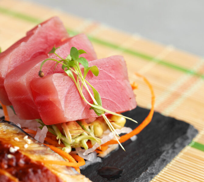 Sashimi sushi sliced fish served on stone plate close up