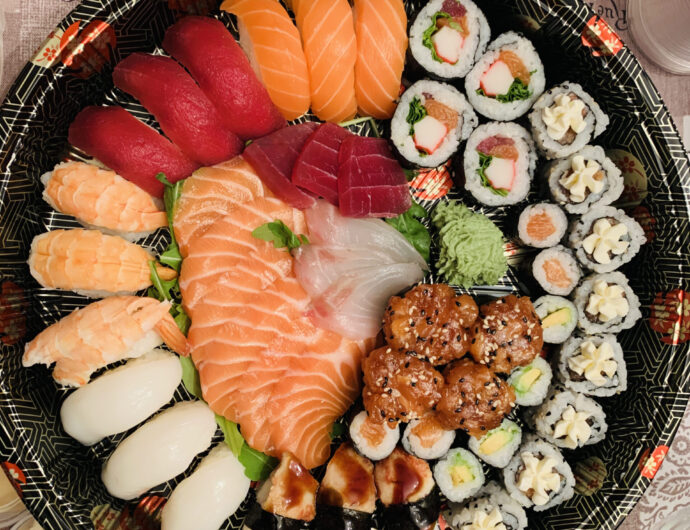 A top view of a large tray with sushi and seafood